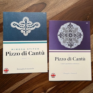 May include: Two magazines with white lace designs on the covers. The covers are blue and purple. The magazines are titled "Mimosa Stitch Pizzo di Cantù" and "Pizzo di Cantù".