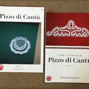 May include: Two issues of a magazine titled "Pizzo di Cantù" featuring white lace designs. The first issue is titled "Issue n° 1" and the second issue is titled "The Curves, Issue n° 2".