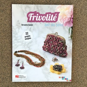 May include: A book titled "Frivolité avec des perles" by Bernadette Baldelli, featuring 22 simple projects. The cover shows a pink and green crocheted purse, a necklace, earrings, and a flower brooch.