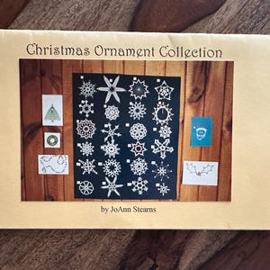 May include: A booklet titled "Christmas Ornament Collection" showcasing various festive designs. The image displays a collection of snowflake and holiday-themed ornaments on a dark background, with additional small illustrations. The text is visible.