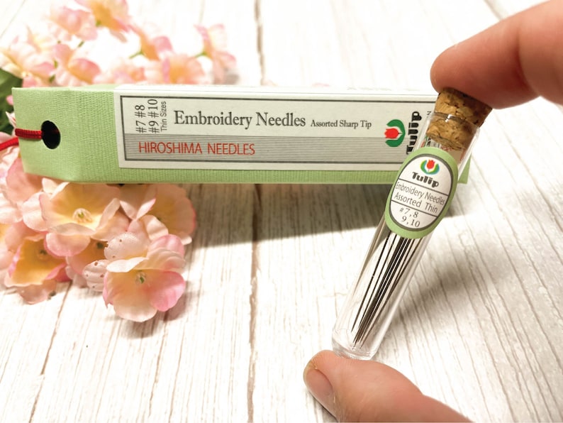 Puede incluir: Un tubo de vidrio lleno de agujas de bordado finas surtidas en tama&ntilde;os 7, 8, 9 y 10. El tubo est&aacute; etiquetado como "Tulip Embroidery Needles Assorted Thin".