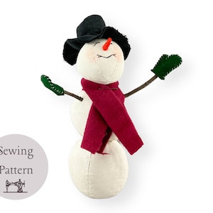 May include: A white snowman with a black hat, red scarf, and green mittens. The snowman has a carrot nose and a stitched smile. The image includes the text "Sewing Pattern" with a sewing machine icon.