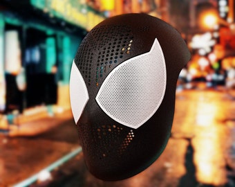 May include: Black and white 3D printed mask with a spider-like design. The mask has a mesh pattern and is designed to cover the face.