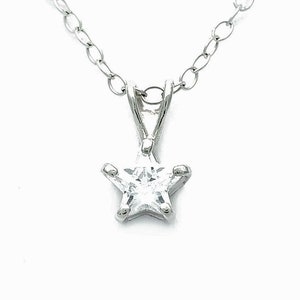 May include: A silver chain necklace with a small, clear star-shaped pendant.