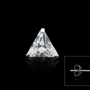 Puede incluir: Un pendiente de plata con una piedra de circonita cúbica transparente de forma triangular.