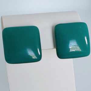 May include: A pair of teal blue square-shaped earrings. The earrings are made of a smooth, glossy material.