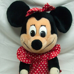 Peut inclure: Un jouet en peluche de Minnie Mouse, la petite amie de Mickey Mouse. Elle porte une robe rouge &agrave; pois blancs et un n&oelig;ud rouge dans les cheveux. Elle a des oreilles noires et un nez noir.