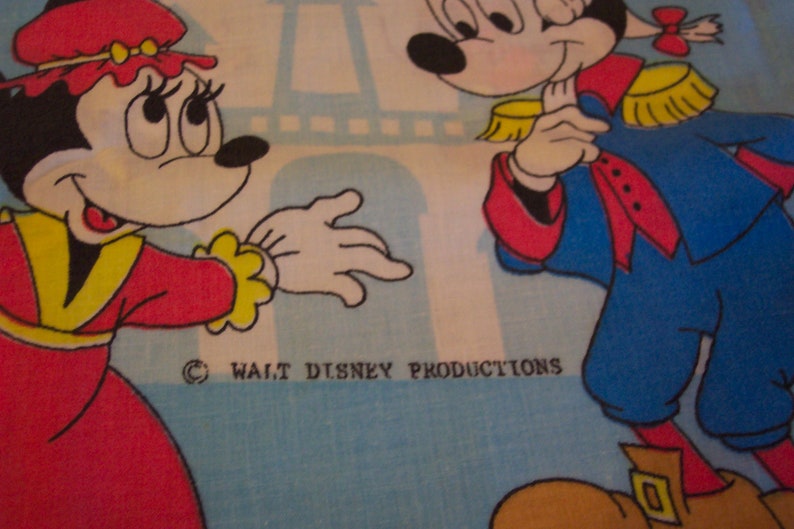 Puede incluir: Un personaje de dibujos animados rojo y amarillo con un lazo en la cabeza y un vestido rojo y amarillo. Est&aacute; de pie junto a un personaje de dibujos animados azul y blanco con un sombrero amarillo y una faja roja. El fondo es azul y blanco con una Torre Eiffel blanca.