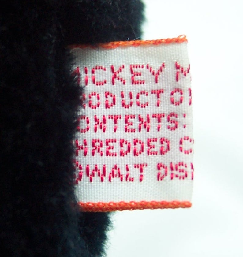 May include: White tag with red text that reads "Mickey Mouse Product Contains Shredded Contents, Small Parts".