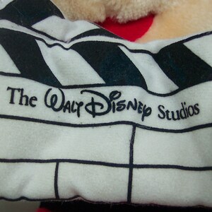 Pu&ograve; includere: Una clapperboard bianca e nera con il testo "The Walt Disney Studios" stampato su di essa.