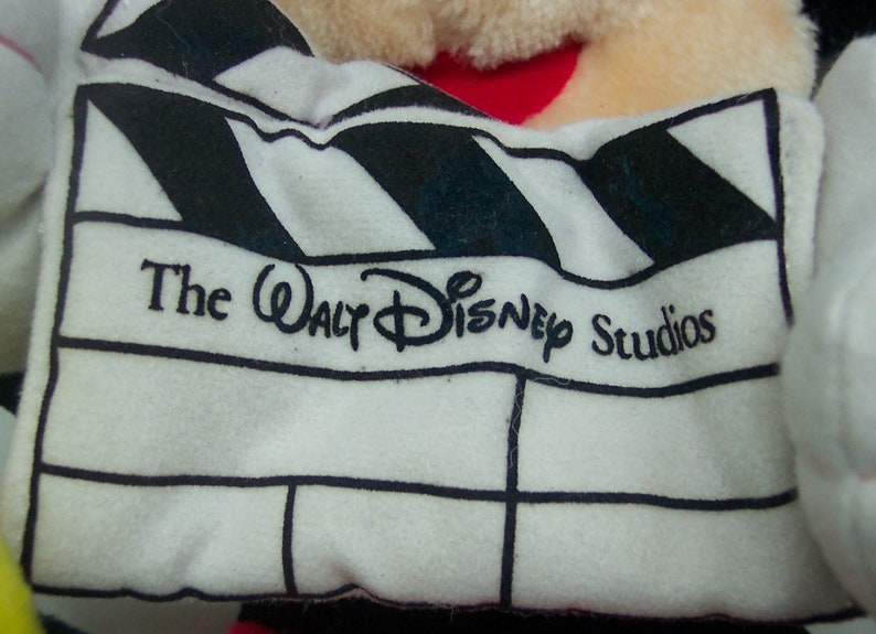 Pu&ograve; includere: Una clapperboard bianca e nera con il testo "The Walt Disney Studios" stampato su di essa.