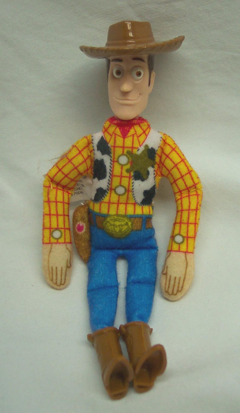 Puede incluir: Un peluche del personaje Woody de la pel&iacute;cula Toy Story. Woody lleva un sombrero de vaquero marr&oacute;n, una camisa a cuadros amarilla, un chaleco con estampado de vaca, vaqueros azules y botas marrones. Tiene una placa de sheriff y una hebilla.