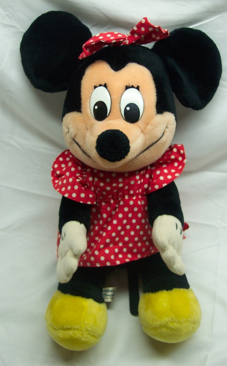 Peut inclure: Un jouet en peluche de Minnie Mouse, la petite amie de Mickey Mouse. Elle porte une robe rouge &agrave; pois blancs et un n&oelig;ud rouge dans les cheveux. Elle a des oreilles noires et un nez noir.