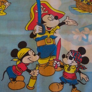 Puede incluir: Tres ratones de dibujos animados vestidos de piratas. El rat&oacute;n del centro lleva un sombrero rojo y blanco y sostiene una espada. El rat&oacute;n de la izquierda sostiene un telescopio. El rat&oacute;n de la derecha sostiene una espada. Los tres ratones llevan pa&ntilde;uelos.