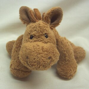 May include: A brown plush horse toy with a long mane and a small, black nose. The horse is lying on its belly with its legs outstretched.