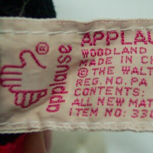 May include: Pink and white fabric tag with the text "Applause Woodland Hills Made in China &copy; The Walt Disney Reg. No. PA 436 Contents: All New Material Item No: 33086"