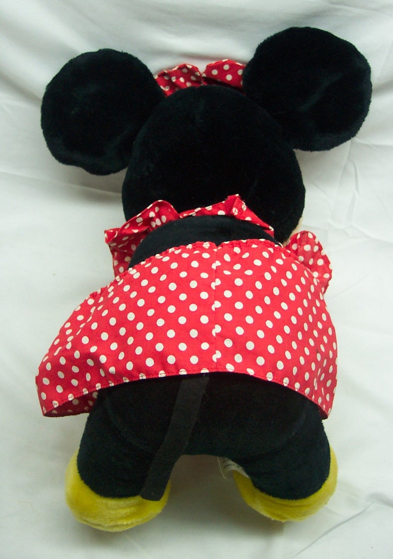 Peut inclure: Un jouet en peluche noir et rouge avec une jupe &agrave; pois rouges et blancs. Le jouet a de grandes oreilles noires et un visage noir.