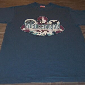 May include: A navy blue short-sleeve t-shirt featuring a graphic print that reads World Reunion, Walt Disney World 25th Anniversary, 1971-1996, with an illustration of Mickey Mouse, a castle, and the number 25 in a circular design.