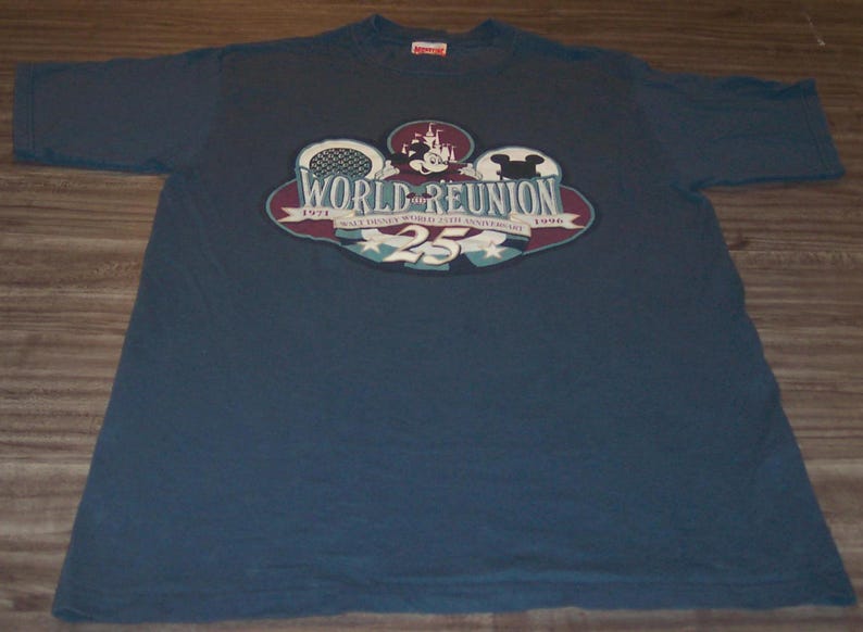 May include: A navy blue short-sleeve t-shirt featuring a graphic print that reads World Reunion, Walt Disney World 25th Anniversary, 1971-1996, with an illustration of Mickey Mouse, a castle, and the number 25 in a circular design.