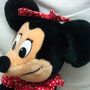 Peut inclure: Un jouet en peluche repr&eacute;sentant Minnie Mouse, la petite amie de Mickey Mouse. Elle porte une robe &agrave; pois rouges et blancs et un n&oelig;ud rouge &agrave; pois blancs. Ses yeux sont grands et noirs, et son nez est noir.
