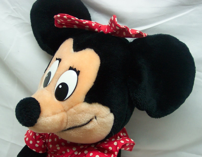 Peut inclure: Un jouet en peluche repr&eacute;sentant Minnie Mouse, la petite amie de Mickey Mouse. Elle porte une robe &agrave; pois rouges et blancs et un n&oelig;ud rouge &agrave; pois blancs. Ses yeux sont grands et noirs, et son nez est noir.