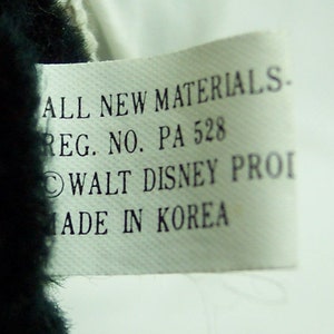 May include: White tag with black text that reads "ALL NEW MATERIALS. REG. NO. PA 528 &copy;WALT DISNEY PROI MADE IN KOREA".