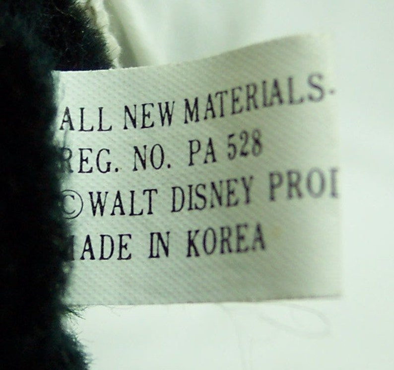 May include: White tag with black text that reads "ALL NEW MATERIALS. REG. NO. PA 528 &copy;WALT DISNEY PROI MADE IN KOREA".