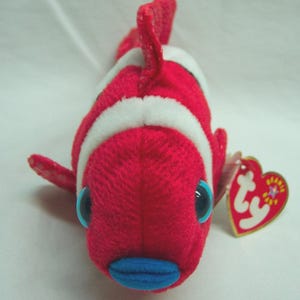 May include: A white ceramic mug with a black handle and the text "But First, Coffee" in a black, handwritten-style font. The mug is on a white surface.