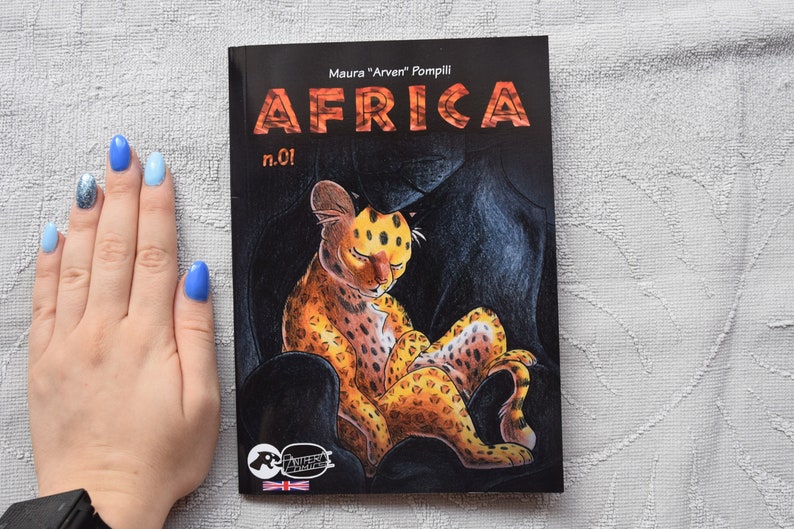 Pode incluir: Uma capa de banda desenhada com fundo preto que apresenta um filhote de guepardo manchado de amarelo e laranja dormindo sobre uma pantera negra. O t&iacute;tulo da banda desenhada &eacute; "AFRICA" com o n&uacute;mero "n.01" abaixo. O nome do autor &eacute; "Maura "Arven" Pompili" acima do t&iacute;tulo.