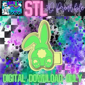 May include: A 3D printable STL file of a green bunny rabbit with a yellow flower on its back. The bunny is facing away from the viewer and has a large, round tail. The text "STL 3D Print File" is visible in the image.