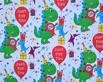 May include: White wrapping paper with a repeating pattern of green dinosaurs wearing party hats, holding presents, and balloons that say "Just For You". The background is white with red, yellow, and blue stars.