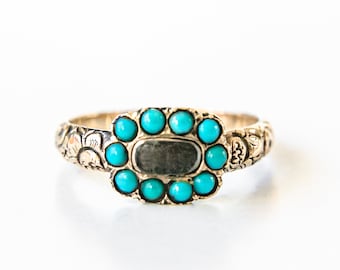 May include: A gold ring featuring a floral design and a cluster of turquoise stones set in a rectangular shape.