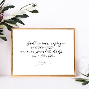 Peut inclure: Une impression encadrée blanche avec une calligraphie noire qui dit "Dieu est notre refuge et notre force, une aide toujours présente dans la difficulté. Psaume 46."