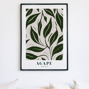 May include: A framed print with a white background and a dark green leafy pattern. The text "AGAPE JOHN 10:17" is printed at the bottom of the print.