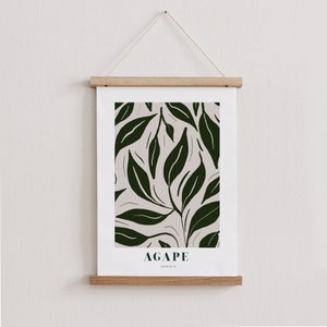 May include: A framed print with a white background and a dark green leaf pattern. The print has the word "AGAPE" and the text "JOHN 13:34" printed below the pattern.