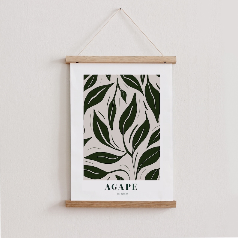 May include: A framed print with a white background and a dark green leaf pattern. The print has the word "AGAPE" and the text "JOHN 13:34" printed below the pattern.