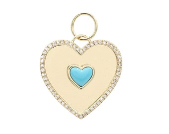 May include: A gold heart-shaped pendant with a smaller turquoise heart in the center. The pendant is surrounded by a border of small diamonds.