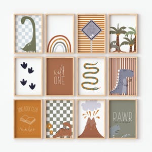 May include: A set of twelve framed art prints with a dinosaur theme. The prints feature illustrations of dinosaurs, rainbows, a volcano, and the text "Wild One", "Dino Book Club", and "Rawr". The colour palette includes shades of brown, green, and blue.