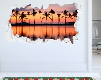 Op de afbeelding: Een muursticker met een zonsondergangscène met palmbomen die tegen een levendige oranje en roze lucht worden geschetst. De afbeelding wordt omlijst door een gebroken muureffect, waardoor een 3D-illusie ontstaat.