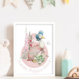 May include: A framed print of Jemima Puddle-Duck, a duck character in a bonnet and dress, set against a pink backdrop with flowers and foliage. The print includes the text "Jemima Puddle-Duck" in a circular design and a butterfly illustration.