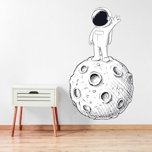 Etiqueta engomada de la pared del espacio - Astronauta estaba saludando en la luna Arte de la etiqueta de la pared de dibujos animados