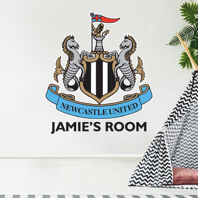 Puede incluir: Un escudo de f&uacute;tbol del club de f&uacute;tbol Newcastle United en blanco y negro con una cinta azul y el texto "NEWCASTLE UNITED" y "JAMIE'S ROOM" debajo del escudo.