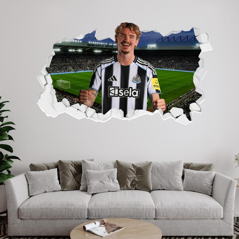 Puede incluir: Un adhesivo de pared que representa a un jugador de f&uacute;tbol con una camiseta a rayas blancas y negras con la palabra "isela". El fondo muestra un estadio con las palabras "Newcastle United". El jugador sonr&iacute;e y parece estar celebrando.