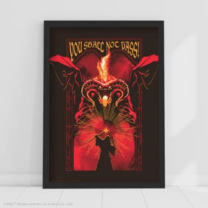 May include: Framed art print featuring a red and black illustration of a Balrog and Gandalf from The Lord of the Rings. The text "YOU SHALL NOT PASS!" is at the top. The artwork is in a black frame.