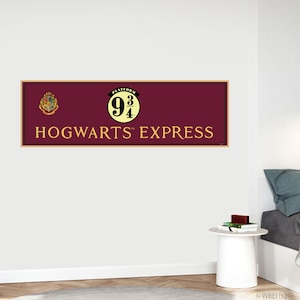 Peut inclure: Une pancarte rouge et or avec le texte "Platform 9 3/4" et "Hogwarts Express". La pancarte présente les armoiries de Poudlard et un cercle jaune avec le numéro de la plateforme.