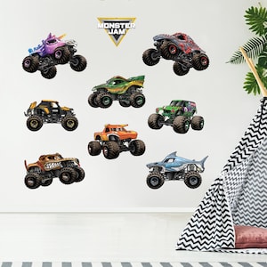 May include: A set of eight Monster Jam monster truck decals featuring various trucks with different colors and designs, including a purple truck with a unicorn horn, a green truck with a dragon design, a black truck with a skull design, an orange truck with a monster face, a blue truck with a shark fin, a red truck with a monster face, a green truck with a monster face, and a black truck with a monster face. The decals are all on a white background. The text "Monster Jam" is at the top of the image.