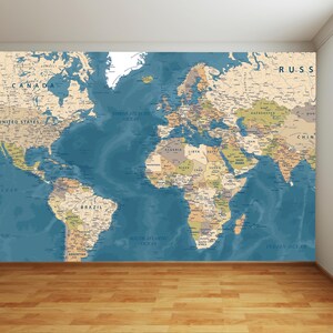 Peut inclure: Une grande carte du monde murale d'esthétique vintage, avec un océan bleu et des masses terrestres beiges. Les noms des pays sont étiquetés dans une police classique. La carte est fixée au mur au-dessus d'un plancher en bois.