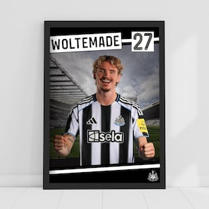 Puede incluir: Impresión enmarcada de un jugador de fútbol con una camiseta a rayas blancas y negras. El texto "WOLTEMADE - 27" es visible. El jugador sonríe, con un estadio de fondo. El logotipo del equipo es visible.