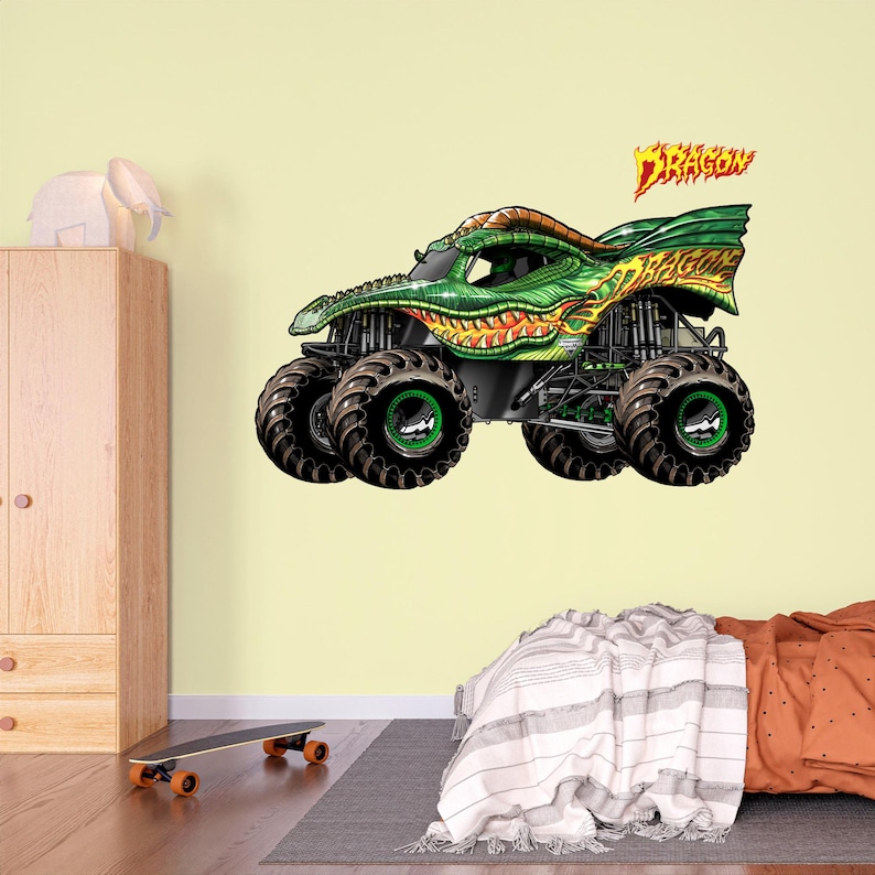 May include: A green and yellow monster truck with the word "DRAGON" in flame-like lettering. The truck has large black tires with green rims and a detailed dragon-scale design on the body. The image is a vibrant illustration.