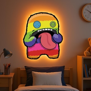 Op de afbeelding: Een kleurrijk, regenboog gestreept monster met een grote, tanden glimlach en een lange, roze tong die uitsteekt. Het monster heeft twee grote knoop ogen met groene en blauwe centra. Het monster wordt verlicht met een warme, oranje gloed.